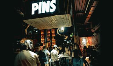 PINS Social Club entrance with a large PINS sign overhead.