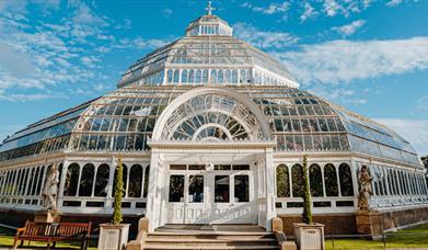The Palm House, an ornate glass house in the sunshine.