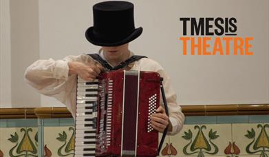 A person wearing a black top hat covering their eyes. They are standing playing a red accordion.