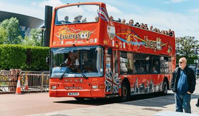 Red City Sights bus with tourists on the top deck.